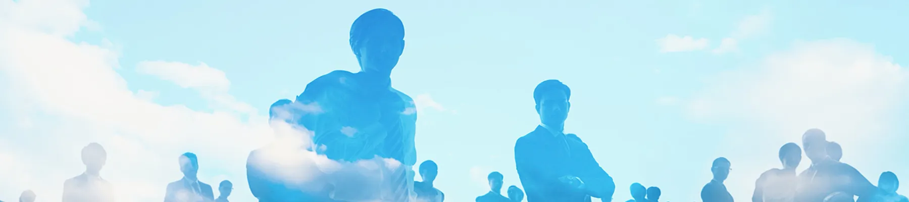 青空と雲を背景にした、ビジネスパーソンのシルエットのイメージビジュアル。